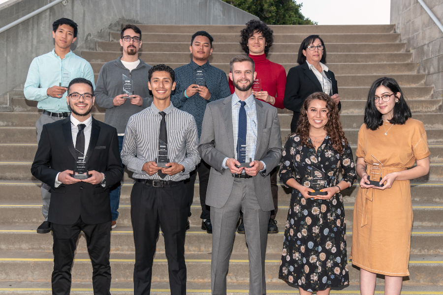 ten citrus college students pose on campus steps while holding achievement awards