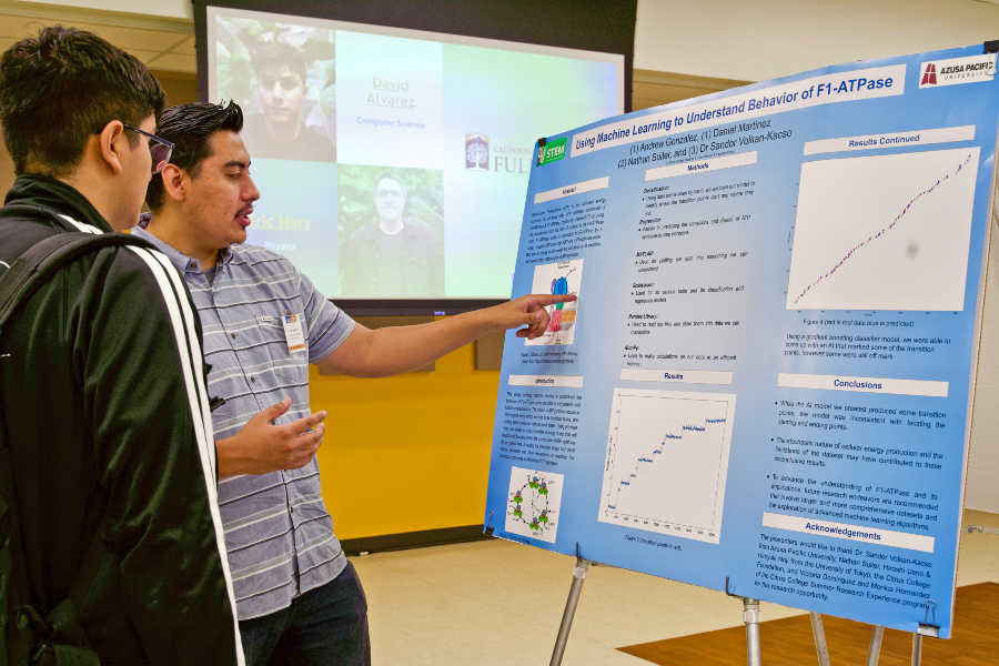 student explains a machine learning research poster to another student during the citrus college stem summer research symposium