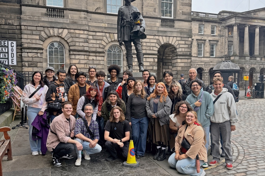 citrus college emerging theatre technologies students, faculty and staff pose beneath the james braidwood statue in edinburgh's parliament square, where the monument is decorated with traffic cones