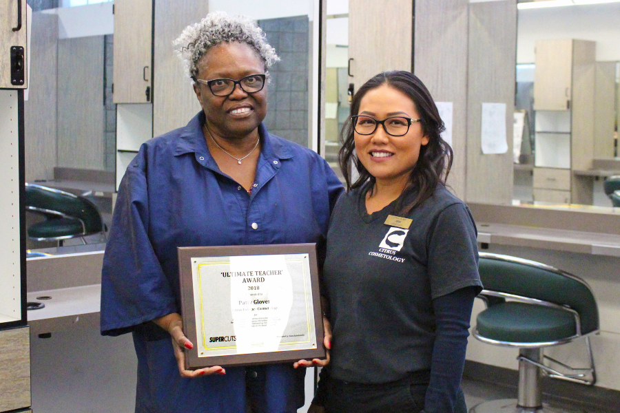 cosmetology instructor patty glover holds her ultimate teacher award beside student heang lao in the citrus college salon