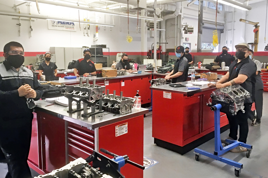 automotive technology students wearing masks work at spaced stations with engine components in a citrus college lab