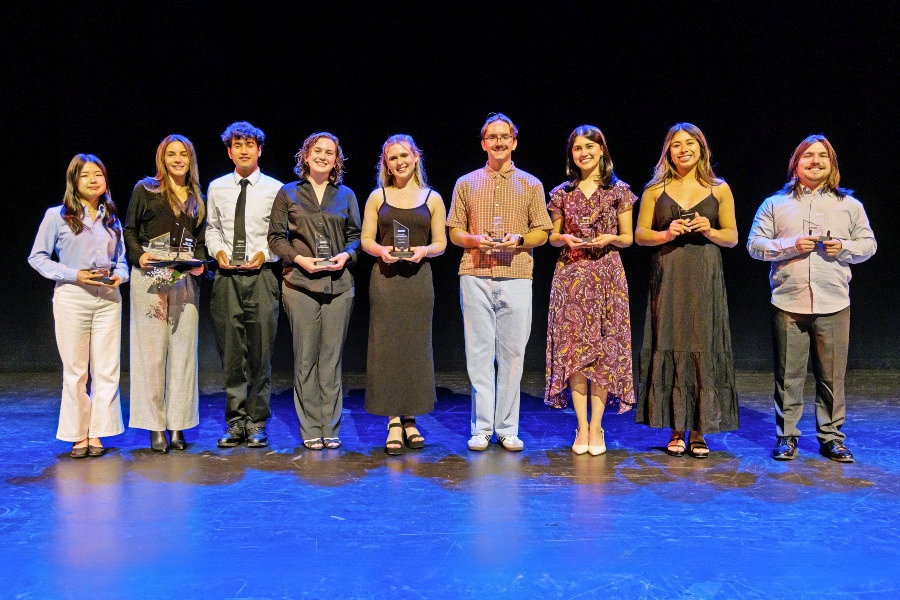 students stand on stage holding achievement awards during a citrus college ceremony