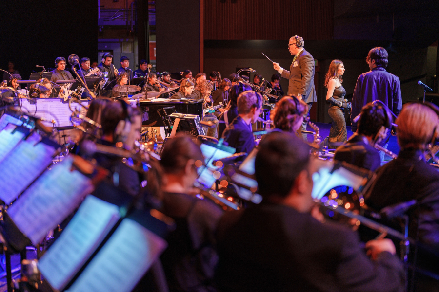 blue note swing orchestra performs on stage at the haugh performing arts center while a conductor leads the ensemble