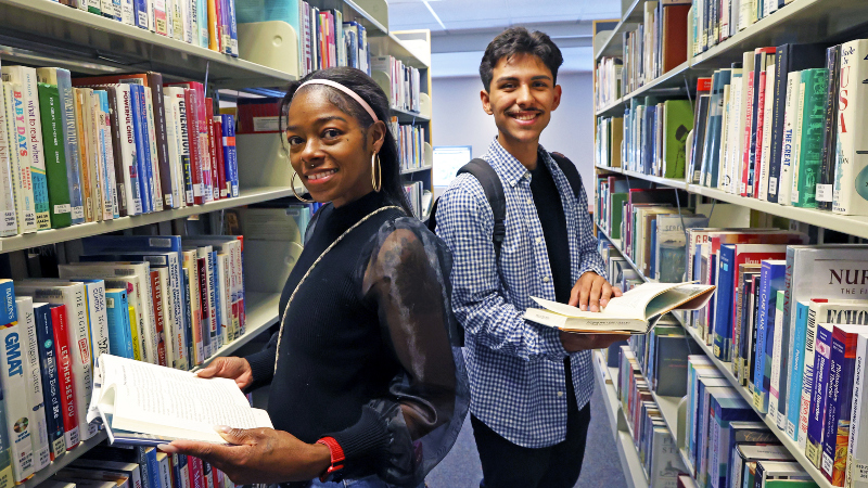 two students looking for books in the racks at the Citrus College Library