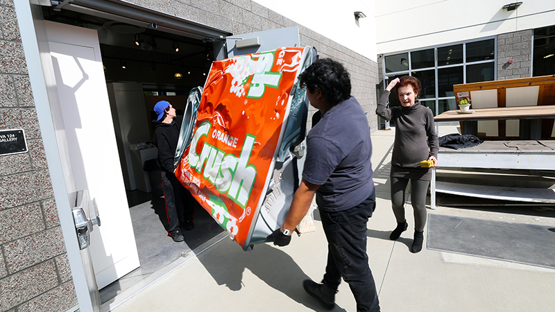 special installers carefully moving the pop art pieces into the college's art gallery
