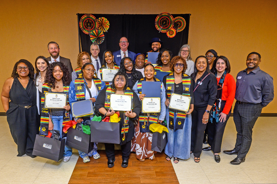 black scholars honorees pose with certificates, stoles and gift bags during a campus recognition celebration