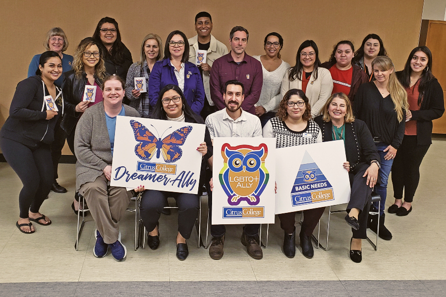 citrus college employees pose together while holding dreamer ally, lgbtq ally and basic needs signs after an ally training session