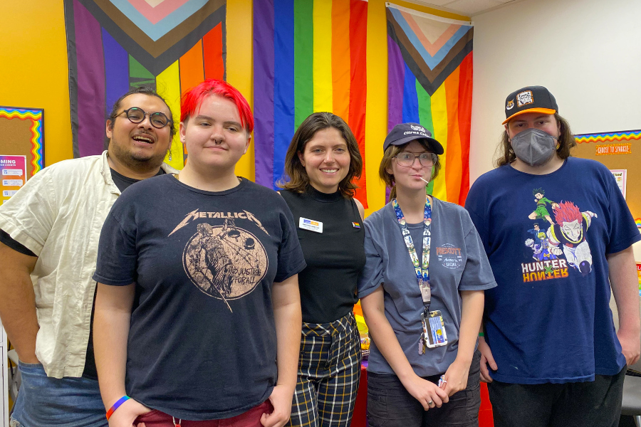 students and staff gather in the citrus college pride center with pride flags displayed on the walls