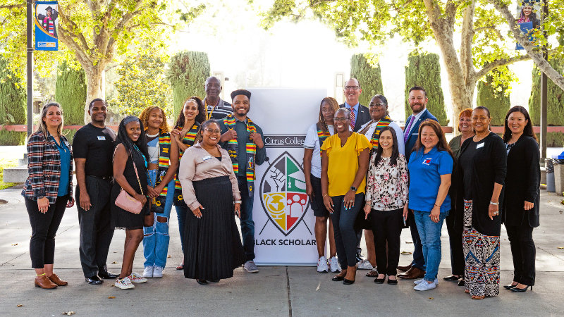 a group of staff and administrators with the Black Scholars banner 