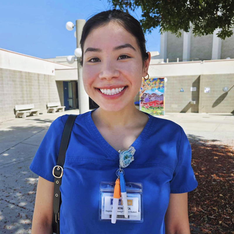 a smiling Melissa Mendoza in blue scrubs