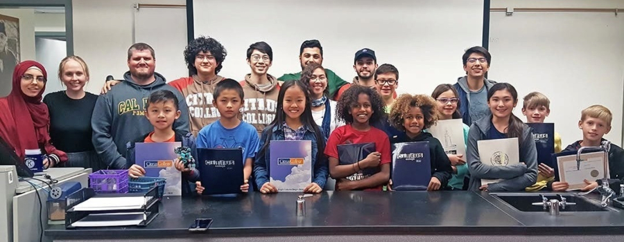 rocket owls students and participants pose together in a classroom, with several children holding citrus college folders and certificates