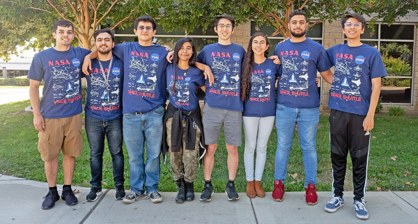 eight citrus college students wearing matching nasa space shuttle shirts pose together outdoors on campus