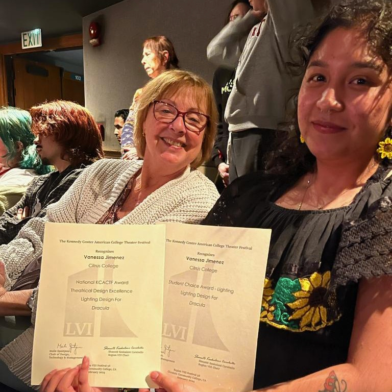 Vanessa Jimenez holding her award certificates next to her instructor, Cherie Brown